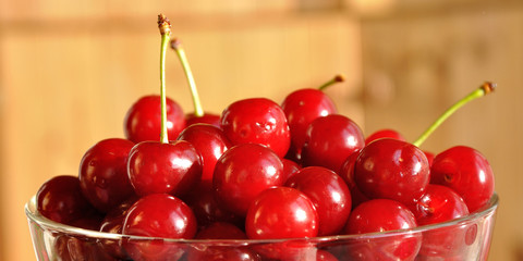 glass bowl full of red ripe cherries