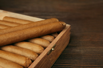 Cigars in humidor on wooden table, closeup