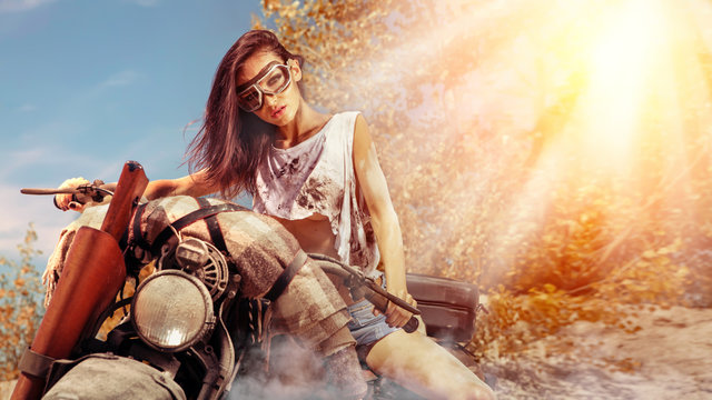 Sexy biker woman on the autumn background.
