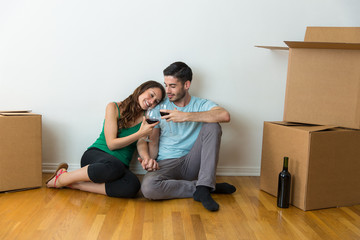 married couple move into their first house together and celebrate with glass bottle of red wine