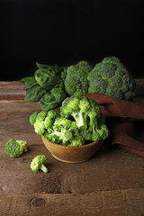 Fresh broccoli with spinach in bowl on dark background