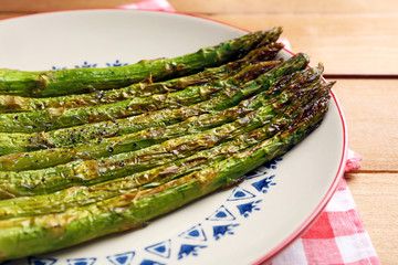 Roasted asparagus on plate on table background
