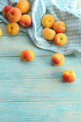 Ripe apricots with napkin on wooden table close up