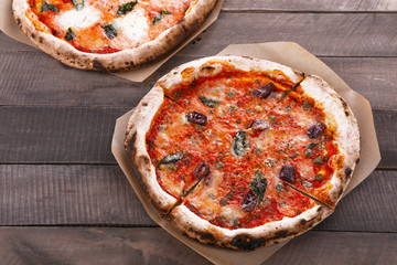 Delicious pizzas on wooden table, closeup