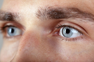 Fototapeta premium Beautiful blue man eyes close up