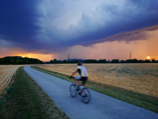 Mountainbiker fährt Richtung Gewitter.