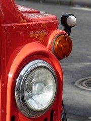 Scheinwerfer eines roten Londoner Doppelstockbus der Sechziger Jahre im Sommer bei Sonnenschein...