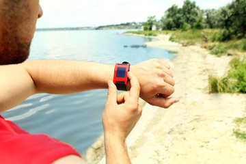 Runner looking at sports smart watch outdoors