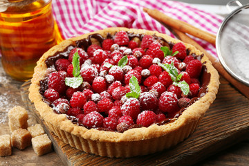Tart with fresh raspberries, on wooden background