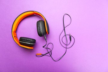 Headphones with clef of cable on purple background