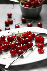 Sweet cherries on plate, on dark background