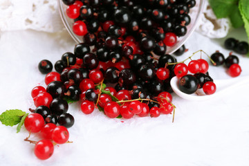 Ripe forest berries in glass bowl on light background