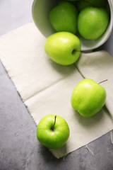Green apples on wooden table with napkin, closeup
