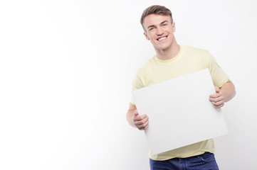 Smiling man holding white sheet of paper 