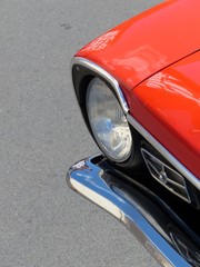 Rotes amerikanisches Coupé der Siebziger Jahre auf grauem Asphalt im Sommer beim Oldtimertreffen...