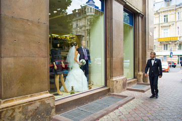 The groom is walking beside the showcase.