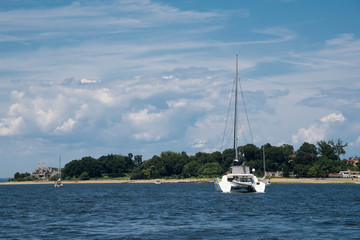 Fototapeta na wymiar Luxury white catamaran anchored by the shore