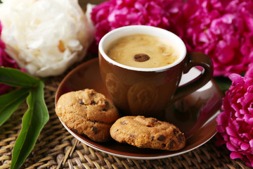 Composition with cup of coffee and peony flowers on wooden background
