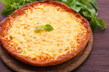 Cheese pizza with basil on table close up