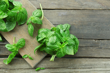 Green fresh basil on wooden background