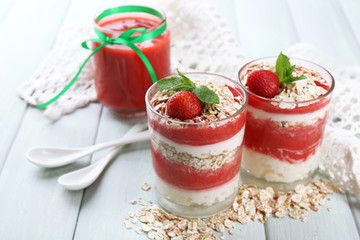 Dessert with fresh strawberry, cream and granola, on color wooden table background