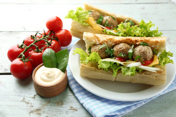 Homemade Spicy Meatball Sub Sandwich on plate, on wooden table background