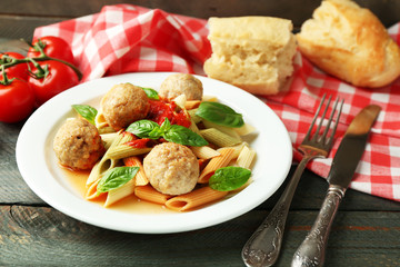 Pasta with meatballs on plate, on wooden  table background