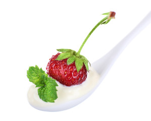 Delicious yogurt in spoon with strawberry and mint isolated on white