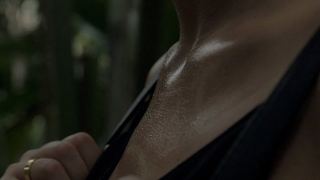 Close up of sweat female chest breathing quickly. Woman alone in the dark forest, fast breathing.