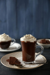 Cup of coffee with cream on color wooden background