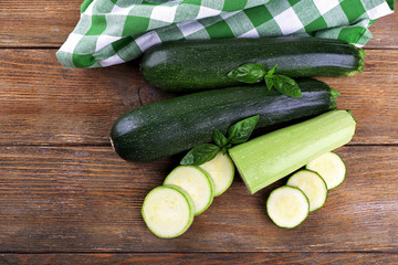 Fresh zucchini with squash and basil on wooden table close up