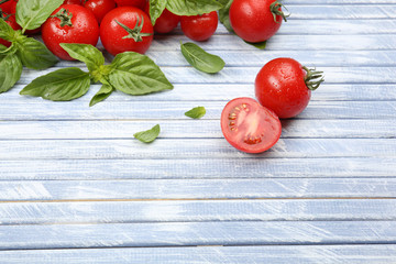 Fresh tomatoes with basil on wooden table close up