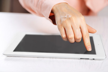 Woman using digital tablet on table close up