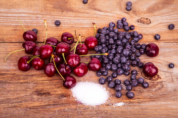 Fototapeta na wymiar bluberry cherry and sugar on old wooden background