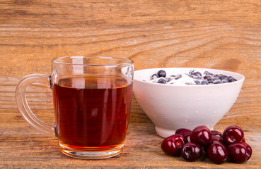 cup of tea sweet cherry and blueberry in white bowl on a wooden