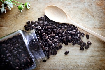 Coffee beans glass background old wood.
