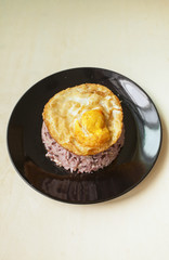 Brown rice with crispy fried egg with space on wood background