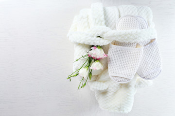 Bath set with white bathrobe and slippers, top view