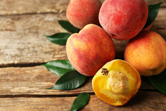 Ripe peaches on wooden background