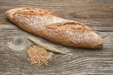 Rustic bread and wheat on an old wood table