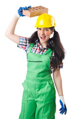 Female workman in green overalls holding brick isolated on white