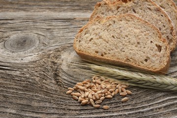 Rustic bread and wheat on an old wood table