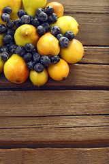 Ripe pears and blueberries on wooden table close up