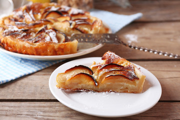 Piece of homemade apple pie on wooden background