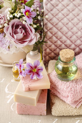 Bottle of essential oil, soft towels and bars of natural handmad
