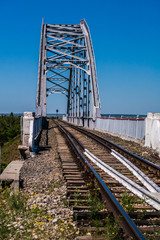 Fototapeta na wymiar Railway bridge across the Canal against the blue sky