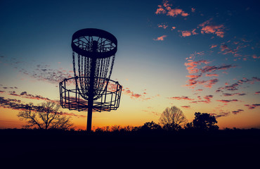 Silhouette of disc golf basket against sunset - 87956617
