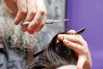 Barber cutting and modeling hair by scissors