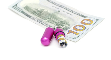 Waterproof metallic capsule-keychain for safe banknotes with twisted greenback
 and hundred dollar bill on white isolated 