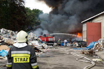 Firefighters extinguishing burning waste dump
